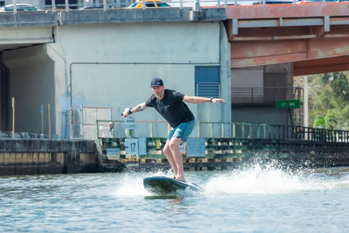 Rider on an Awake RÄVIK Explore electric surfboard during an on-water demo session in Texas
